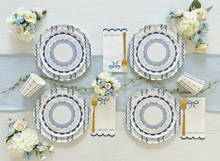 Load image into Gallery viewer, Set of decorative plates with floral arrangements and cutlery on a light blue tablecloth.