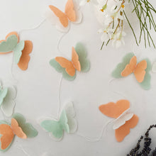 Load image into Gallery viewer, Peach, mint Butterfly felt garland for party and room decoration next to flowers and lavender - Pooka Party
