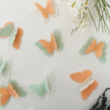 Load image into Gallery viewer, Peach, mint Butterfly felt garland for party and room decoration next to flowers and lavender - Pooka Party
